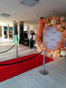 Tapis rouge et arche à ballons à l'entrée du bâtiment